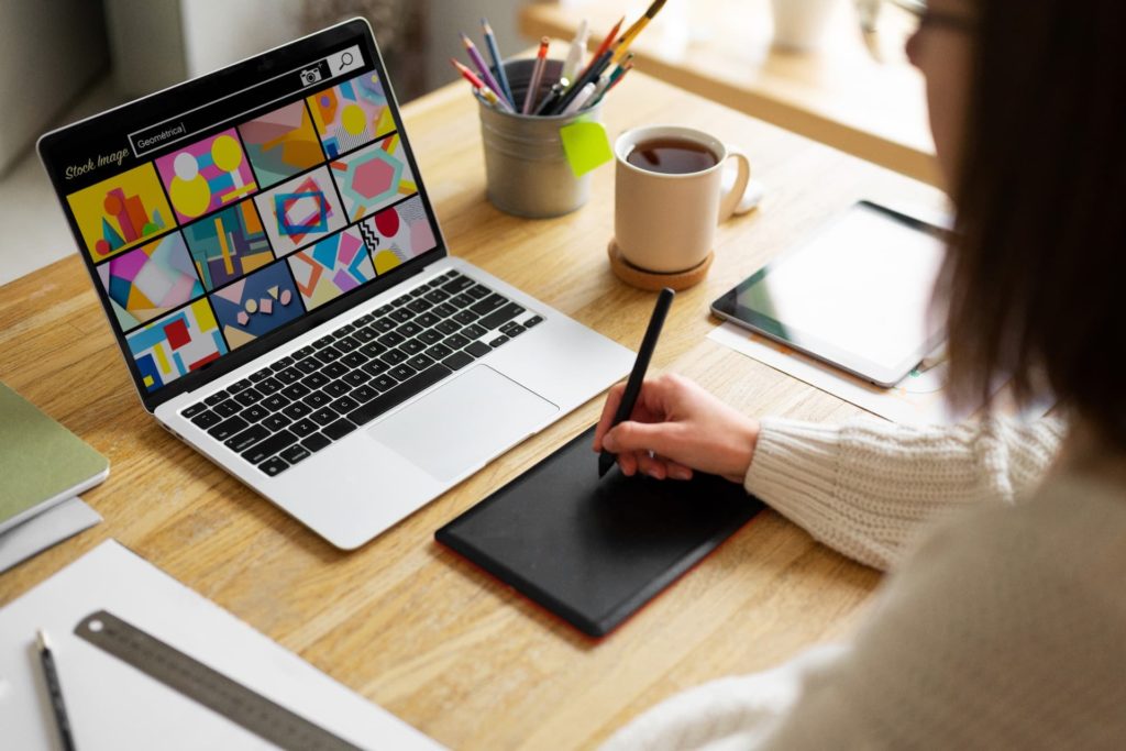 high angle adult searching for stock images on laptop