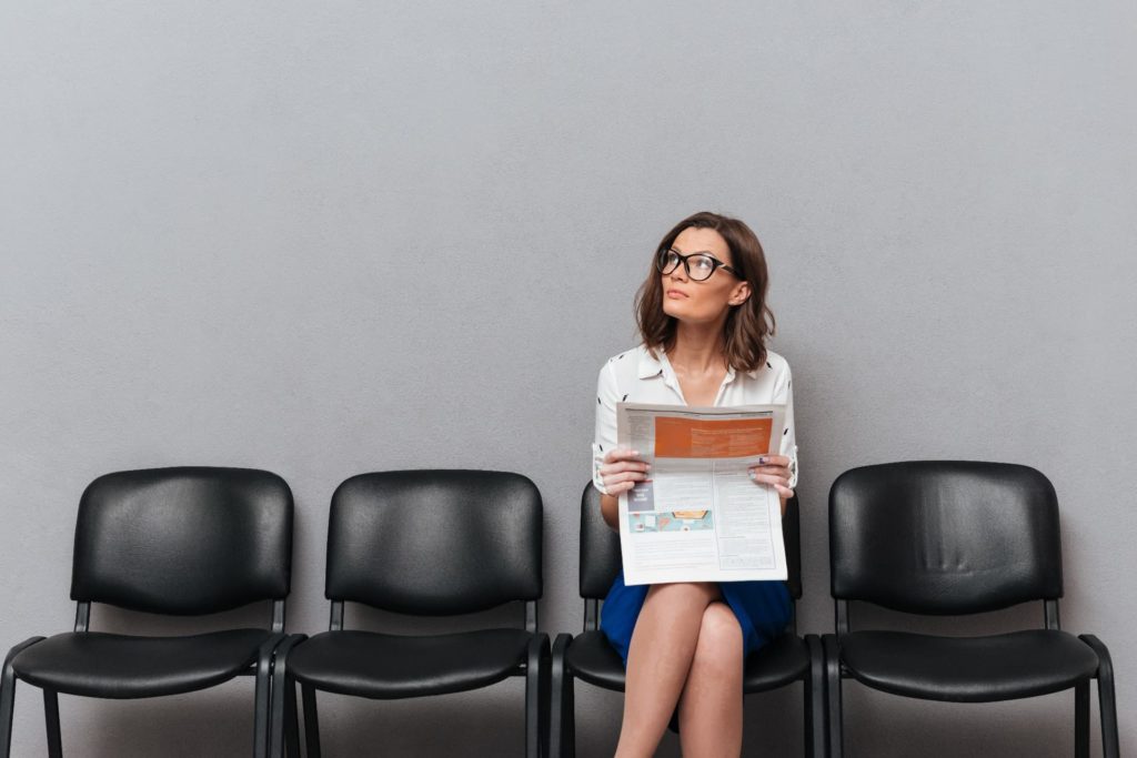 pensive business woman in eyeglasses sitting on chairs