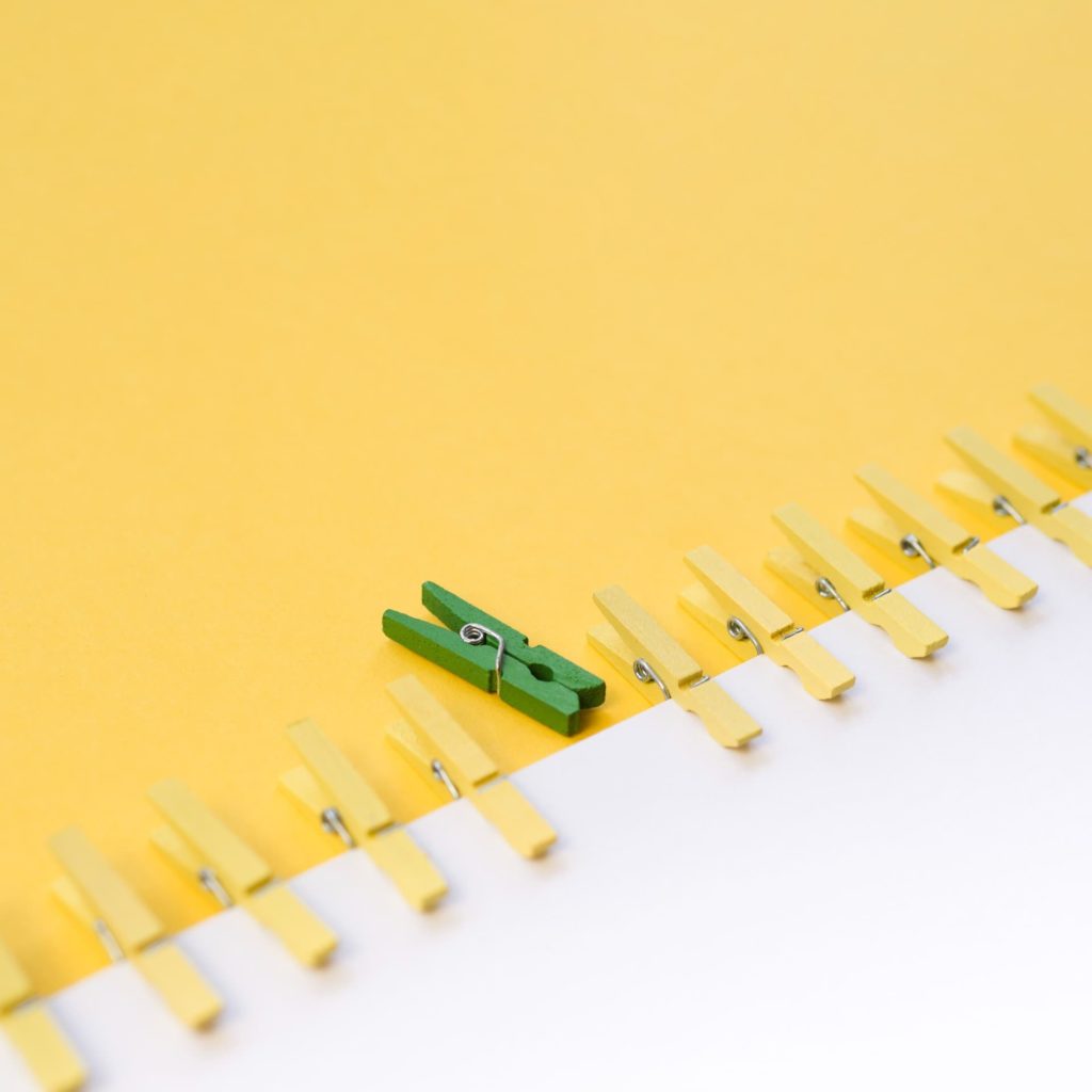 green clothespin surrounded by yellow ones 1